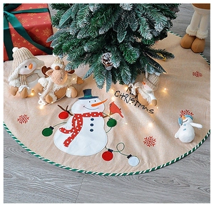 Detailed texture of burlap Christmas tree skirt with snowman and Merry Christmas embroidery