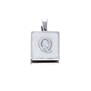 Detailed close-up of a square stainless steel pendant with white shell inlay and letter Q