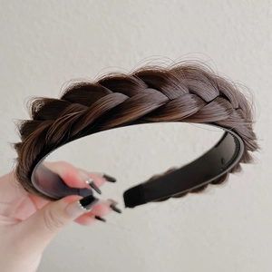 Detail shot of a dark brown braided fishbone headband with inner teeth for a secure fit