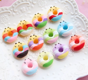 Macro shot of colorful resin donut charms with cute animal faces on a white plate