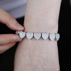 Macro view of heart-shaped links with pave-set cubic zirconia on silver necklace
