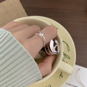 Close-up of 925 sterling silver pearl ring featuring minimalist intertwined band design