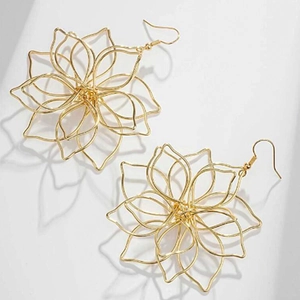 Detail of gold layered hollow floral earrings with intricate twisted metal wire design