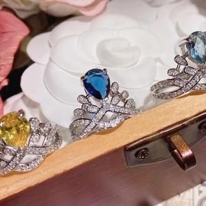 Macro detail of three elegant pear-cut gemstone rings with intricate micro-pave settings