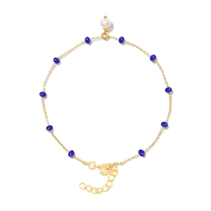 Detailed shot of golden chain bracelet with blue chalcedony beads and a white pearl charm