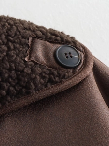 Detail shot of the dark brown suede texture and plush faux shearling lapel of the jacket