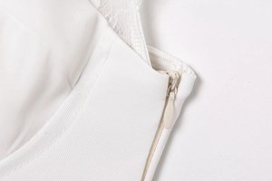 Detailed macro view of high-quality invisible zipper and lace patchwork on white top