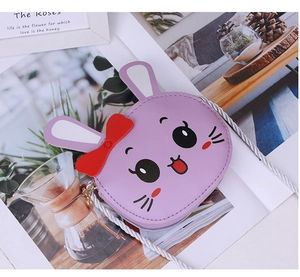 Detailed macro of a purple bunny crossbody bag with embroidery and a red bow decoration