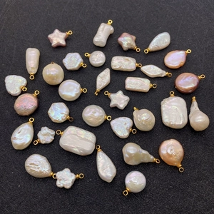 Macro shot of assorted baroque pearl pendants in heart and star shapes on black background