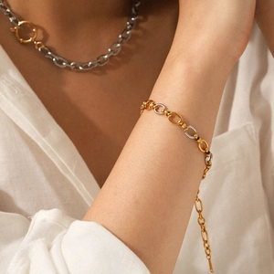 Two-tone gold and silver stainless steel chain bracelet on model with matching necklace