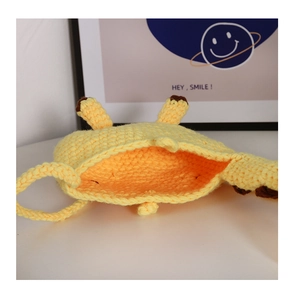 Detail view of the hand-knitted yellow giraffe shoulder bag with interior storage space