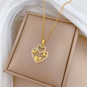 Close-up of a luxury gold double heart pendant with diamonds on a silk background