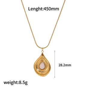 Macro detail of gold teardrop necklace with white gemstone and product dimensions