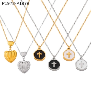 Close-up of textured heart and cross medallion pendants in gold and silver steel
