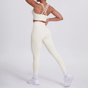 Dettagli del reggiseno yoga con incrocio e leggings sportivi senza cuciture in avorio