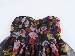 Detail of floral organza puff dress with ruched strapless neckline and black floral pattern