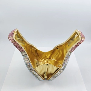 Detail of pink crystal champagne bottle clutch with gold lining and metal chain strap