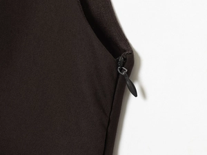 Macro detail of dark brown dress fabric texture and black zipper with metal puller