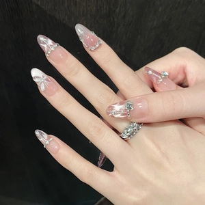 Macro shot of long almond nails with silver butterfly charms and cat eye glitter