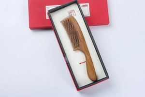 Macro detail of natural sandalwood comb with fine teeth in a premium gift packaging box