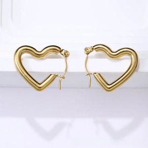 Detailed view of polished 18K gold heart-shaped hoop earrings on a minimalist white stand