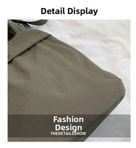 Macro detail of dark green nylon bag showing shoulder strap stitching and side texture