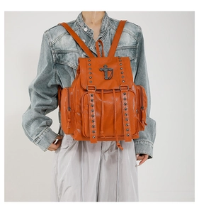 Orange PU leather backpack with silver rivets and cross pendant shown on model