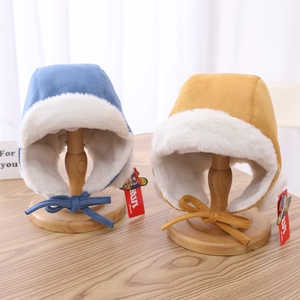 Close-up of blue and yellow winter trapper hats with soft faux fur lining and chin straps