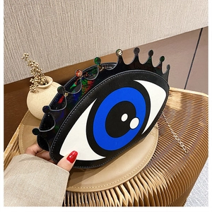 Close-up of creative big eyes crown design shoulder bag with golden metal chain strap