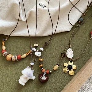 Collier boho avec perles en bois et pendentif cœur en résine avec charme Saturne vintage