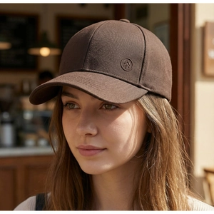 Nahaufnahme einer braunen Baseballkappe mit hartem Oberteil, getragen von einem Modell.