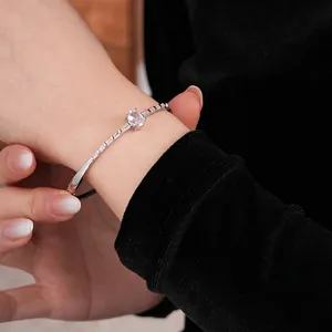 Silver oval zircon metal bracelet with side step-cut stones on a model wrist