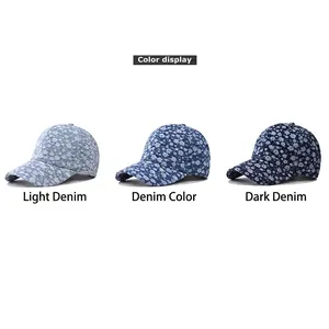 Three washed denim baseball caps with white floral patterns in light to dark blue shades