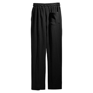 Close-up of black ribbed texture, elastic waistband and back pocket on men's casual pants