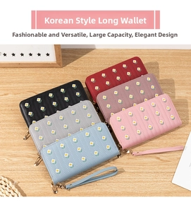 Close-up of long zip-around PU wallets with daisy embroidery and wrist straps in six colors
