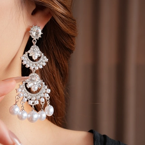Detail of fan-shaped silver tassel earrings with crystals and white imitation pearls