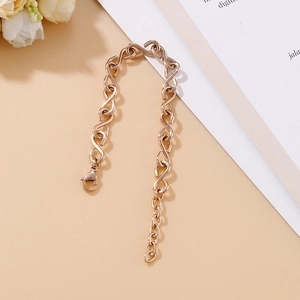 Detail of rose gold infinity S-link bracelet with a lobster clasp on a beige background