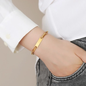 Elegante bracciale in acciaio inossidabile dorato con piastrina rettangolare sul polso