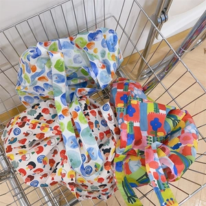Detail of printed canvas tote bags with colorful watercolor patterns in a metal basket