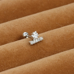 Macro view of silver steel cartilage stud featuring star and bar set with white zircons