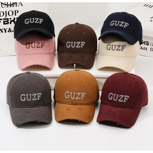 Detail of vintage washed baseball caps in eight colors with GUZF letter embroidery