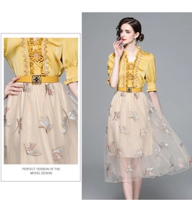 Detail of butterfly embroidery on tulle skirt with satin blouse and yellow belt