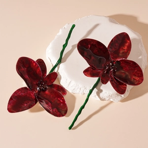 Detail shot of vintage red flower earrings with floral petals and green wavy stems