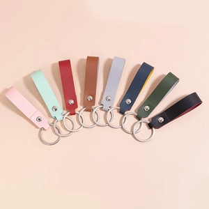 Minimalist PU leather keychains in eight colors with silver rings on beige background