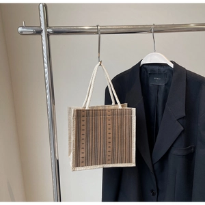 Detail of striped linen tote bag with cream and coffee tones and rope handles