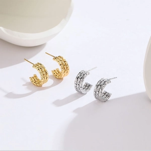 Elegant C-shaped titanium steel hoop earrings in gold and silver with textured star glitter finish