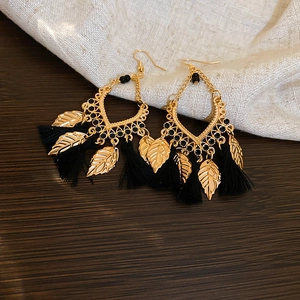 Detailed close-up of Bohemian leaf tassel earrings featuring black silk fringe and gold alloy