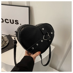 Détail d'un sac cœur en cuir noir avec rivets argentés et boucle métallique élégante