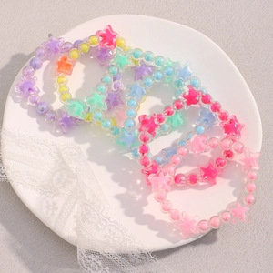 Close-up of colorful jelly star beads in a ceramic dish with lace decor detail