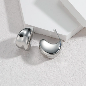 Polished silver bean-shaped stainless steel stud earrings on minimalist white background